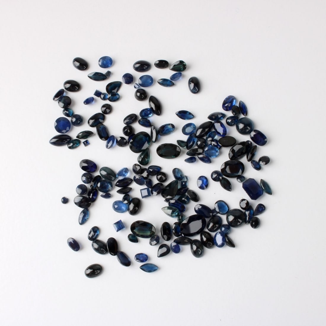 62.3CT TW Sapphires: Approx. 62.3 Carat TW Multi-Cut Natural Sapphires (not mounted). Various sizes, clarity and saturation of color. Kodner Galleries offers phone and absentee bidding at a low, flat 21% buyer’s
