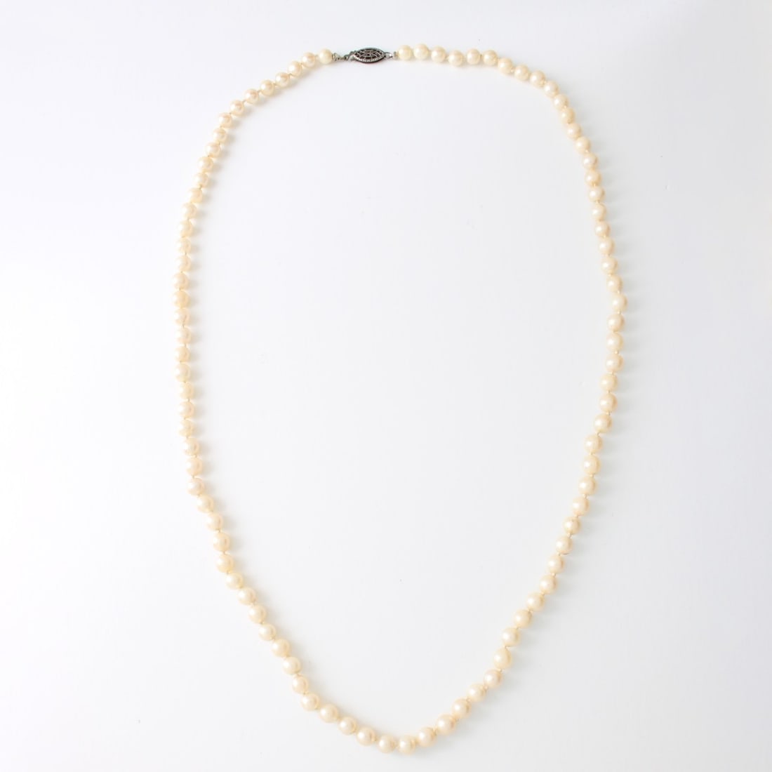 Pearl Necklace: Vintage Single Strand 5.5-5.7mm Pearl Necklace with Silver Filigree Clasp. Measures 24" L. Approx. weight: 24.65 grams. Kodner Galleries offers phone and absentee bidding at a low, flat 21% buyer’s