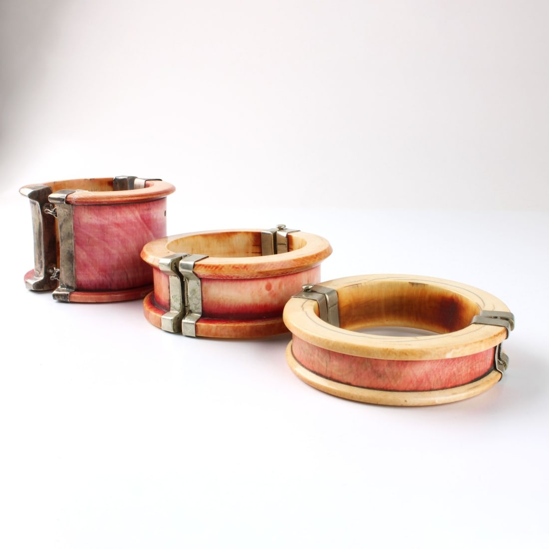 Vintage Carved Cuff Bracelets: Three (3) Vintage Balinese Carved Cuff Bracelets with Silver Hinges. Heights: 2-1/8", 1-1/4", 3/4", inside circumference: 7-3/4". Kodner Galleries offers phone and absentee bidding at a low, flat 21%