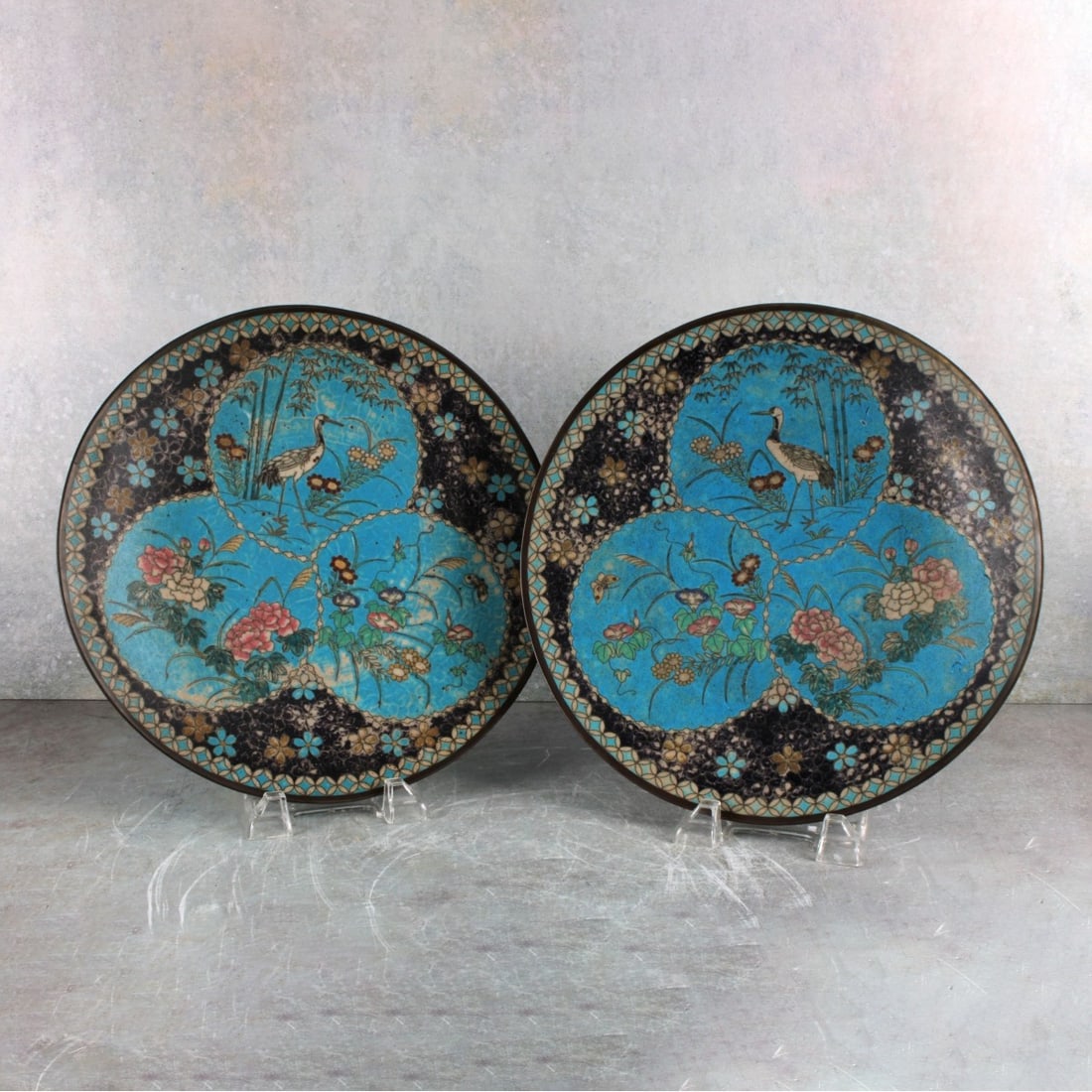 Japanese Bronze and Cloisonne Plates: Two (2) Japanese Meiji Period (1868-1912) Bronze and Cloisonne Display Plates Each Decorated with Three Round Panels Having Standing Cranes and Flowers, the Reverse and Base in Bright Blue with