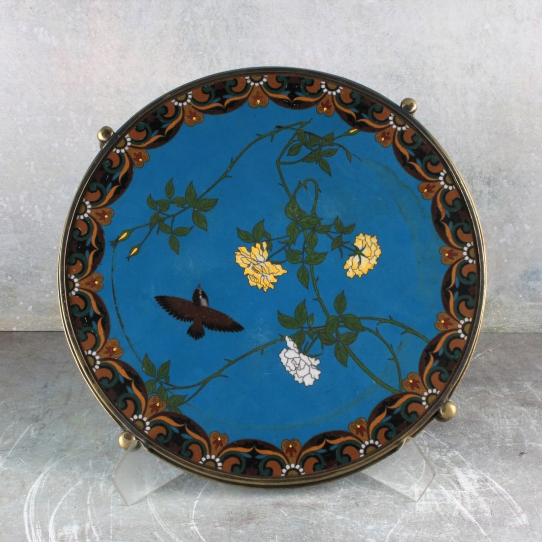 Japanese Bronze and Cloisonne Plateau: Japanese Meiji Period (1868-1912) Bronze and Cloisonne Plateau Decorated with a Small Bird and Flowers, the Reverse and Base in Bright Blue. Measures: 1-1/4" high, 12- 1/4" diameter. Kodner Galleries