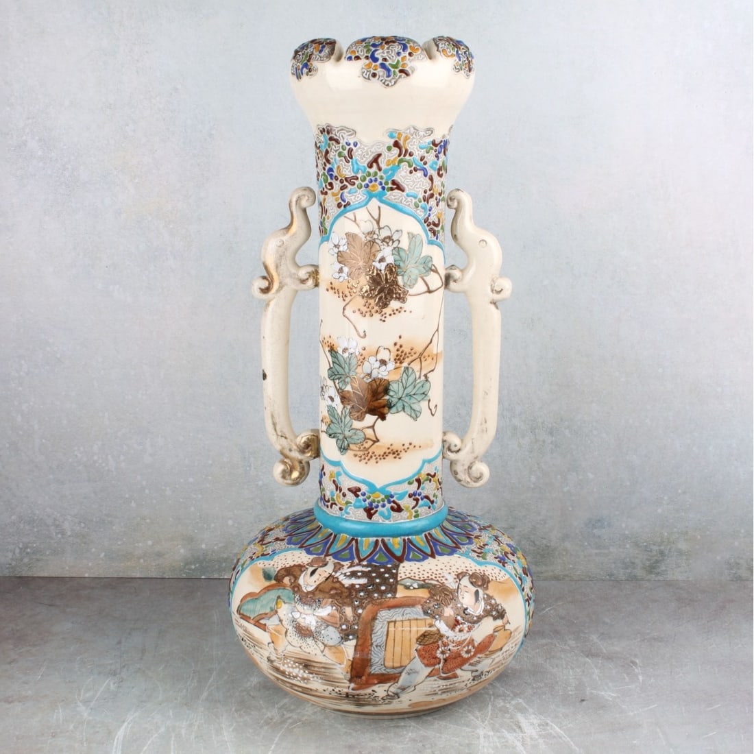 Japanese Satsuma Porcelain Vase: Vintage Japanese Satsuma Porcelain Vase Decorated with Figures and Flowers with Attached Foo Lion Handles. Measures: 21" high, 8-1/2" diameter. Kodner Galleries offers phone and absentee bidding at a