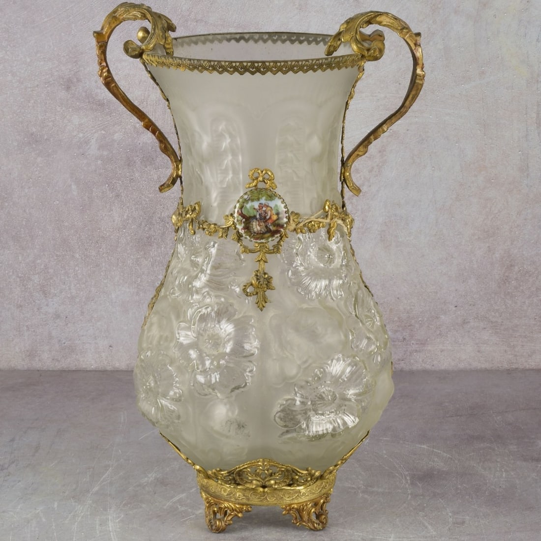 Vintage Frosted Glass Vase: Vintage Frosted Glass Ormolu Mounted Double Handled Vase Raised on Four Feet With an Affixed Cameo Depicting a Rococo Style Romantic Scene in a Landscape. Measures: 14-1/2" high, 7" diameter. Kodner