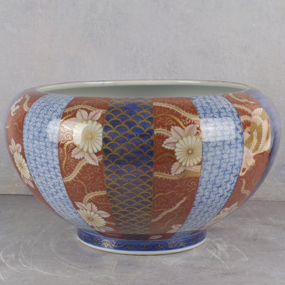 Vintage Japanese Imari Fish Bowl: Vintage Japanese Partial Gilt Imari Porcelain Fish Bowl Decorated with Flowers and Dragons and a Central Koi Fish. Artist signed to the bottom. Measures: 9" high, 5" diameter. Kodner Galleries offers