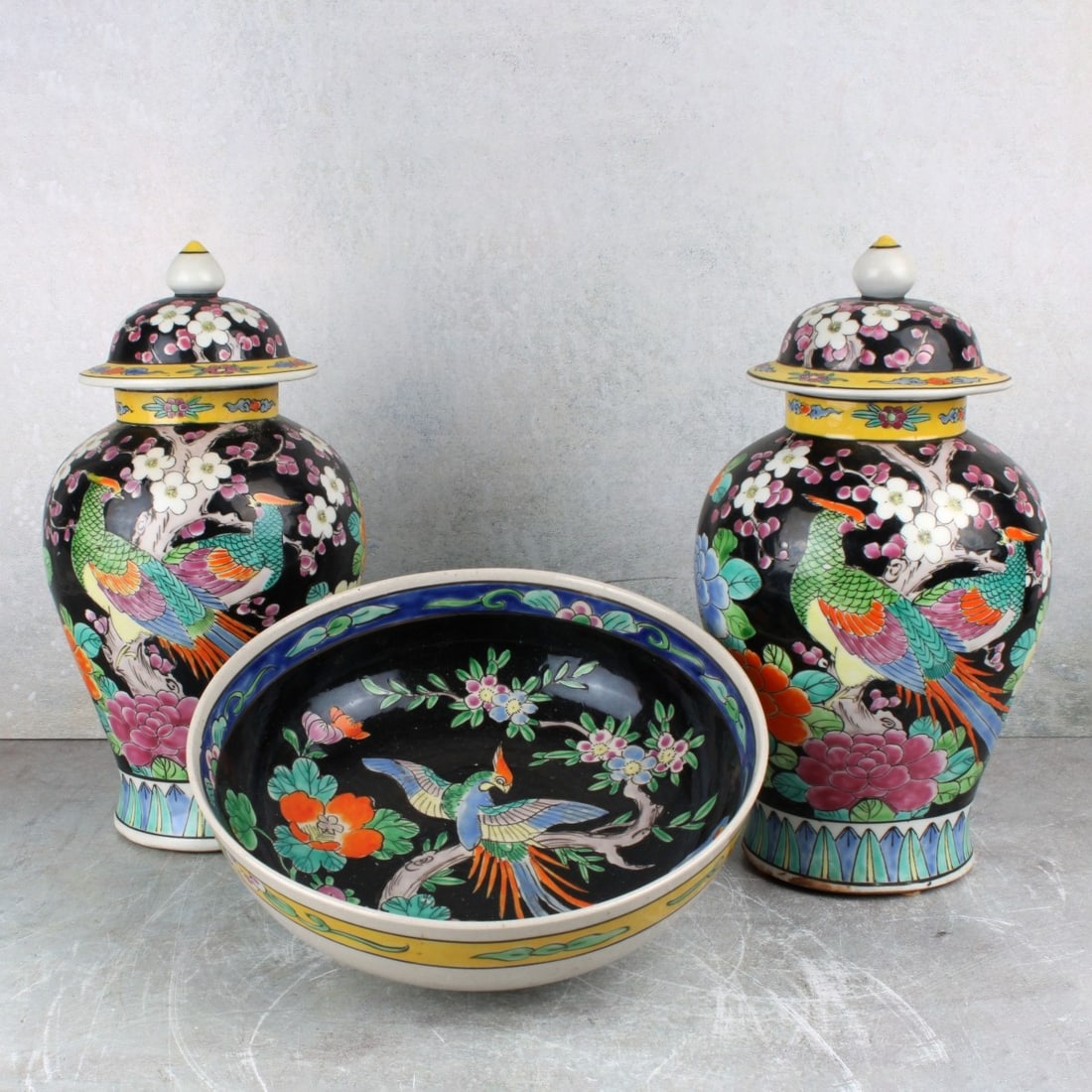 Japanese Satsuma Porcelain: Vintage Japanese Satsuma Porcelain Including a Pair of Covered Urns with Painted Flowers on a Black Ground. Urns measure: 10-1/2" high, 5" diameter, one (1) bowl with a painted phoenix bird on a