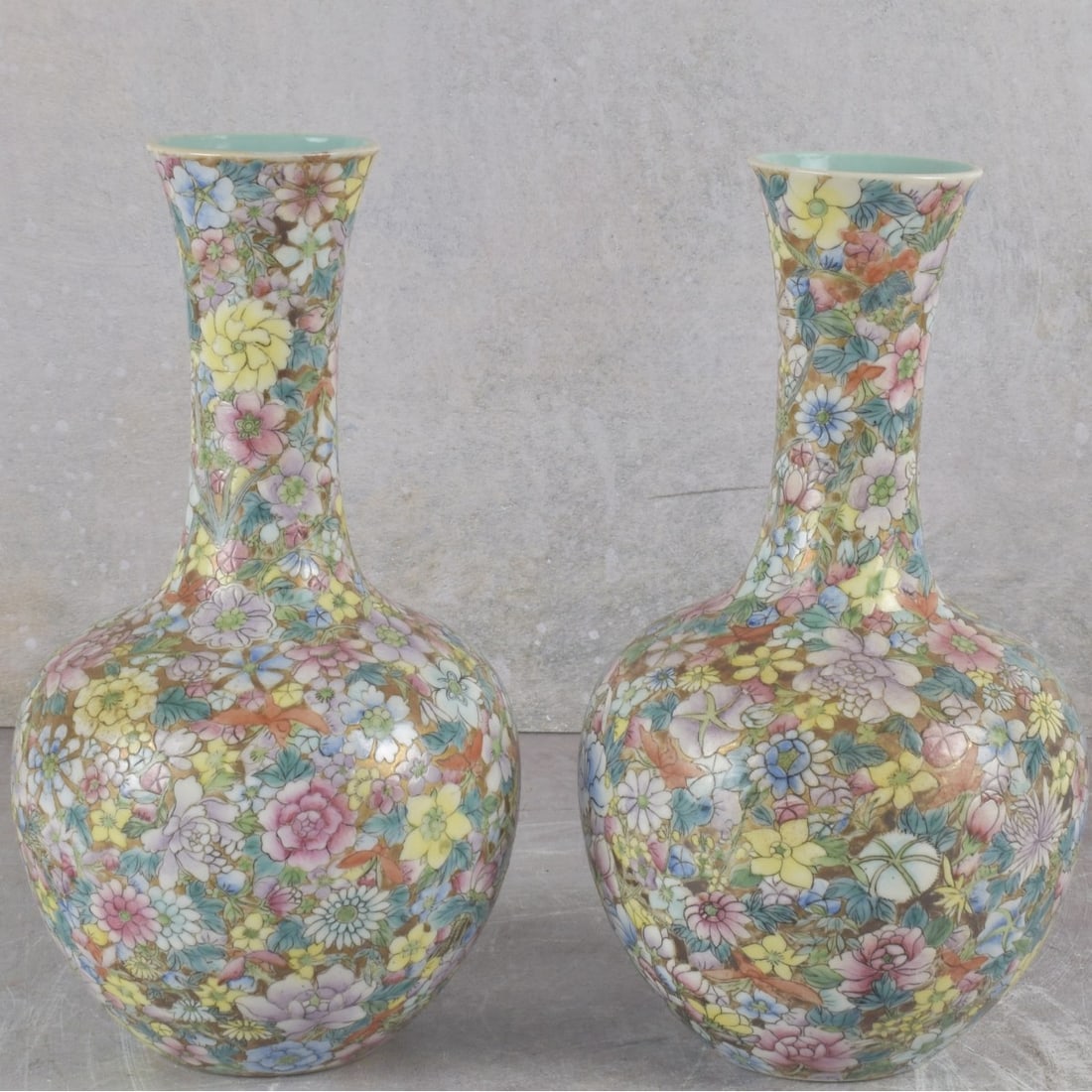 Pair of Chinese Famille Rose Bottle Vases: Vintage Pair of Chinese Famille Rose Bottle Vases. Both signed to the bottoms. Measures: 9" high, 4-1/2" diameter. Kodner Galleries offers phone and absentee bidding at a low, flat 21% buyer’s
