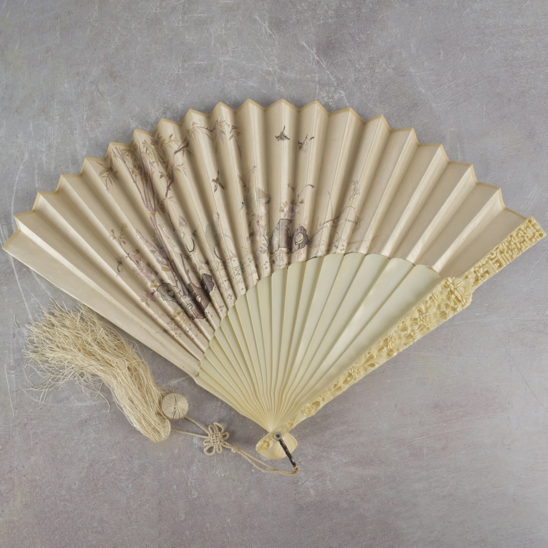 Vintage Chinese Hand-held Folding Fan: Finely Carved Organic Material Vintage Chinese Hand-held Folding Fan with Delicate Embroidered Silk Flowers and Tassels with Blades Having Carved Chinoiserie Scenes and a Custom Lacquered Hinged Case.