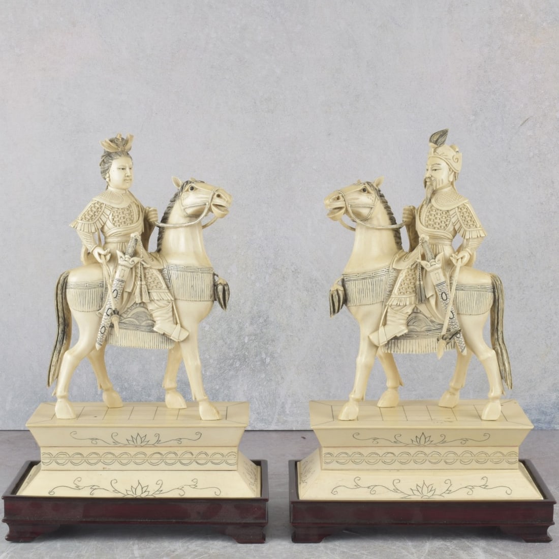 Chinese Emperor and Empress: Pair of Well Carved Organic Material Chinese Emperor and Empress on Horseback Each Holding a Lance with Custom Carved Wood Bases. Sculptures with plinths measure: 10-1/4" high, 6-5/8" wide, 3-3/4" dee