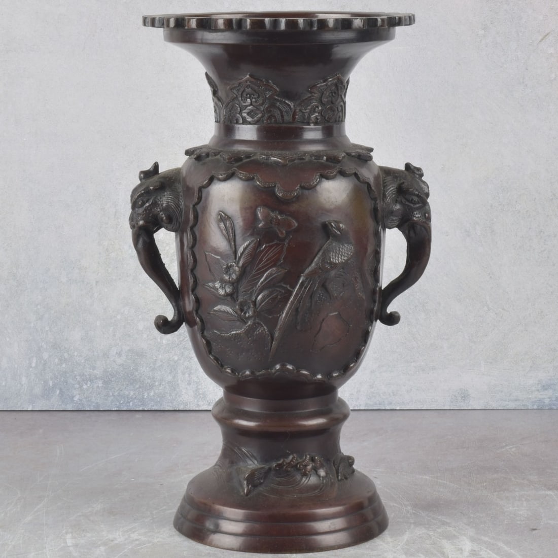 Vintage Japanese Bronze Urn: Vintage Japanese Bronze Urn with Elephant Mask Handles with Flying Birds and Foliage. Measures:12-1/4" high, 7-1/4" wide, 5" deep. Kodner Galleries offers phone and absentee bidding at a low, flat