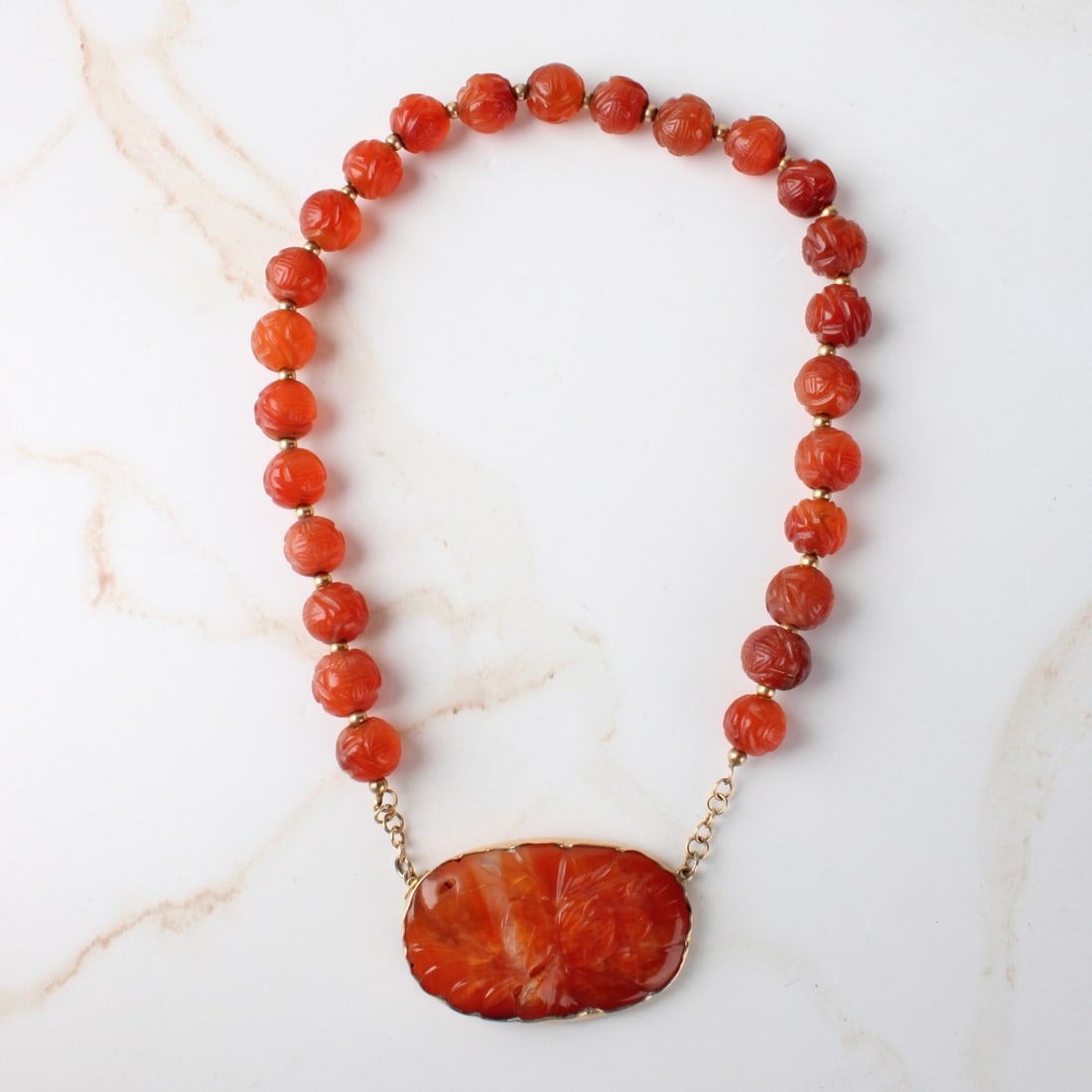 Antique Chinese Carved Carnelian Pendant Necklace.: Antique Chinese Carved Carnelian Pendant Necklace. Pendant measures 1-1/8" H, 1-3/4" W, necklace measures 14-3/4" L. Approx. weight: 52.21 grams. Kodner Galleries offers phone and absentee bidding at
