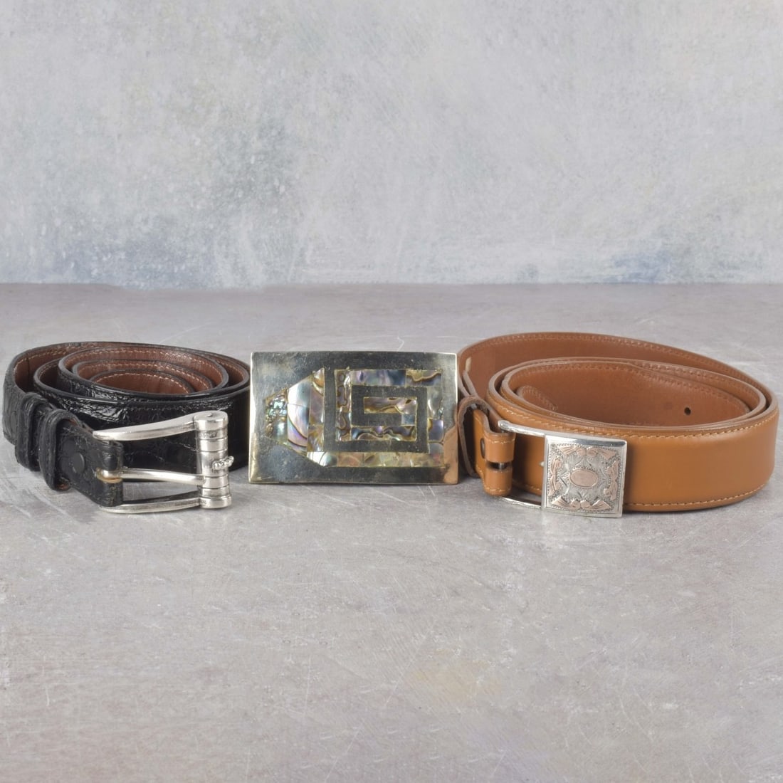 Vintage Men's Leather and Silver Belts: Three (3) Vintage Men's Leather and Silver Belts. Consisting of one (1) black leather belt with silver buckle having abalone insert marked "ALPACA MEXICO" from center hole to end of strap measures: 37