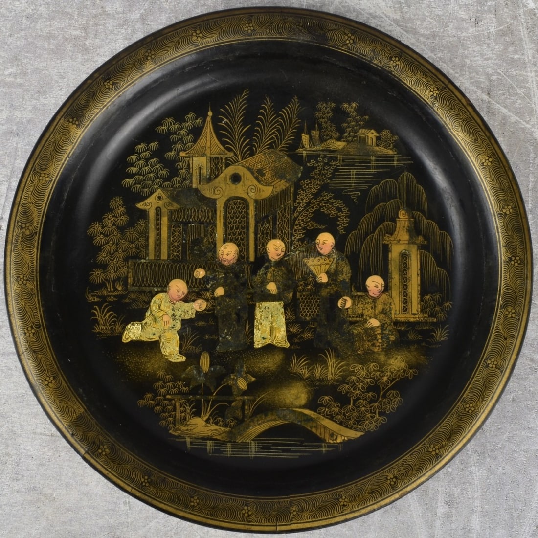 Chinese Lacquered Plate: Antique Chinese 19th Century Black Lacquered Plate with a Gilt Chinese Design. Measures: 3/4" high, 8" diameter. Kodner Galleries offers phone and absentee bidding at a low, flat 21% buyer’s premium