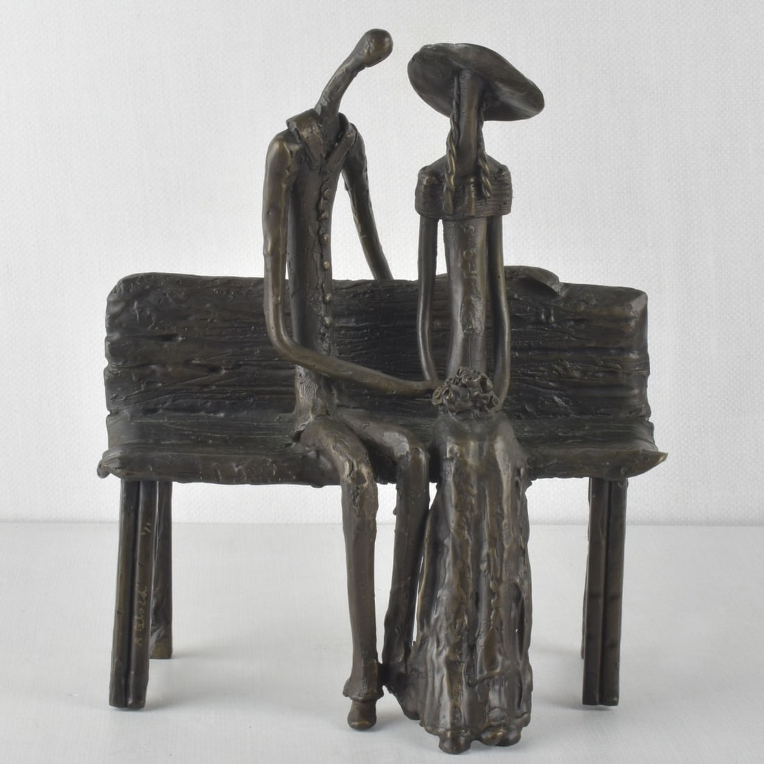 Ruth Bloch, Israeli, (b. 1951): Ruth Bloch, Israeli, (b. 1951) Bronze Modernist Figural Sculpture of a Couple Seated on a Bench Holding Hands with the Lady Holding a Bouquet of Flowers. Signed and numbered "1/1" in the bronze. Measu