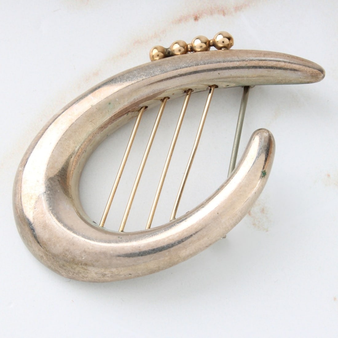 Sterling and 14K Pin: Retro Sterling Silver and 14 Karat Yellow Gold Pin. Stamped 925 14K. Measures 2" H, 1-3/8" W. Approx. weight: 15.07 grams. Kodner Galleries offers phone and absentee bidding at a low, flat 21% buyer��