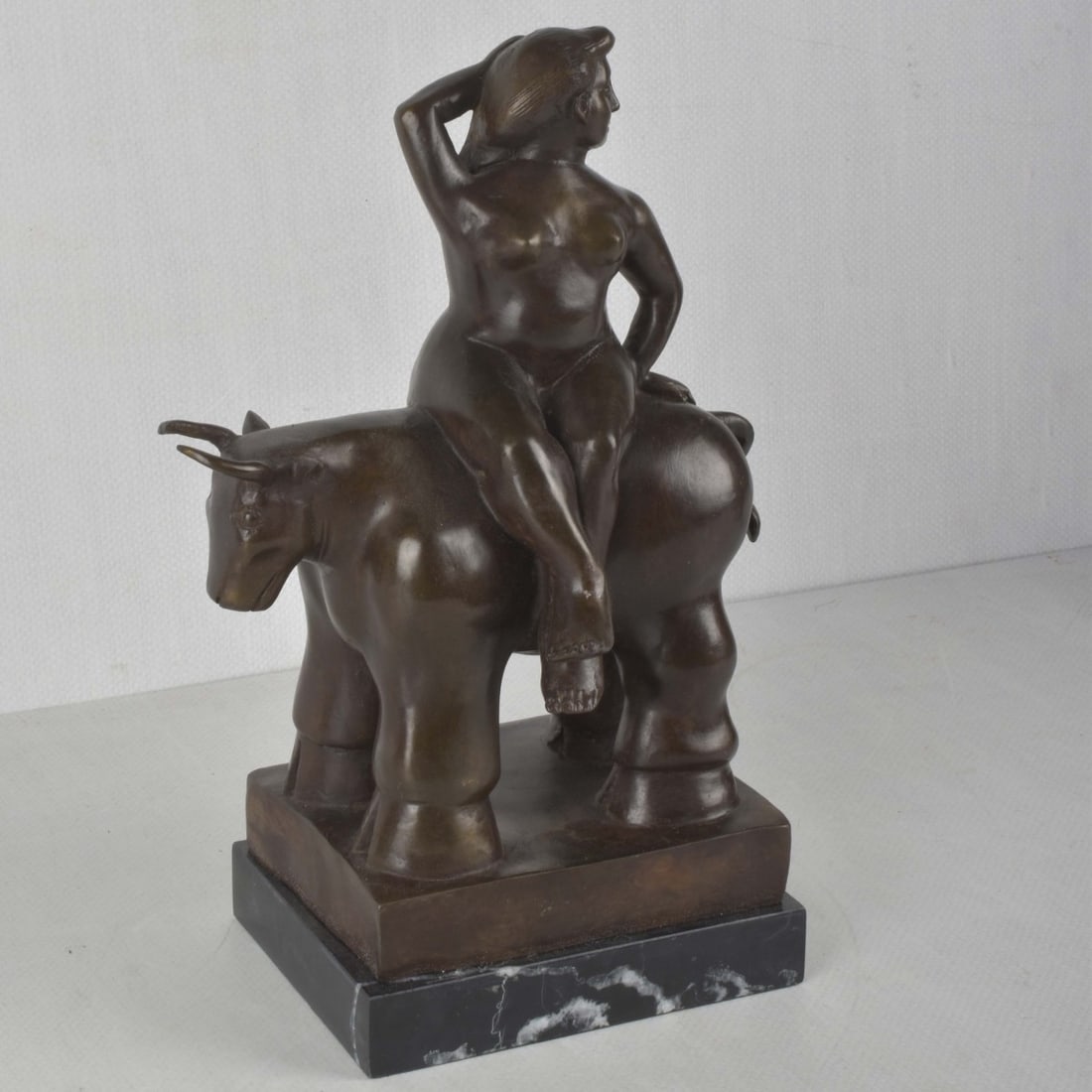 After: Fernando Botero, Colombian (1932-2023): After: Fernando Botero, Colombian (1932-2023), Bronze Sculpture on Marble Base, Lady Astride a Bull. Bears signature. Measures (with base): 12-3/4" H, 8" W. Kodner Galleries offers phone and absentee 