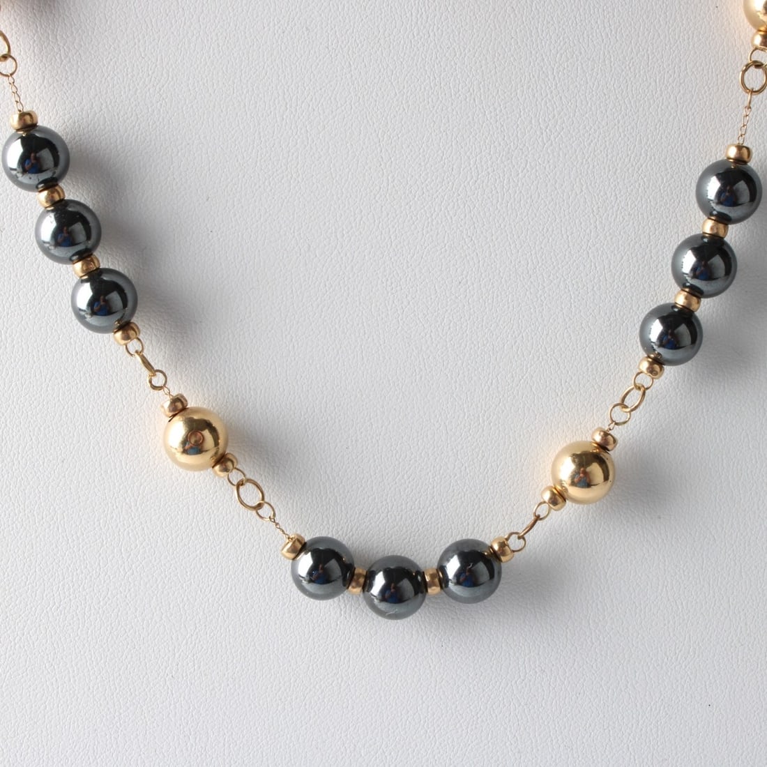 Hematite and 14K Necklace: Vintage 14 Karat Yellow Gold and Hematite Bead Necklace. Hematite beads measure 10mm. Gold beads measure 10mm. Clasp stamped 14K. Necklace measures 27" L. Approx. total weight: 77.84 grams. Kodner