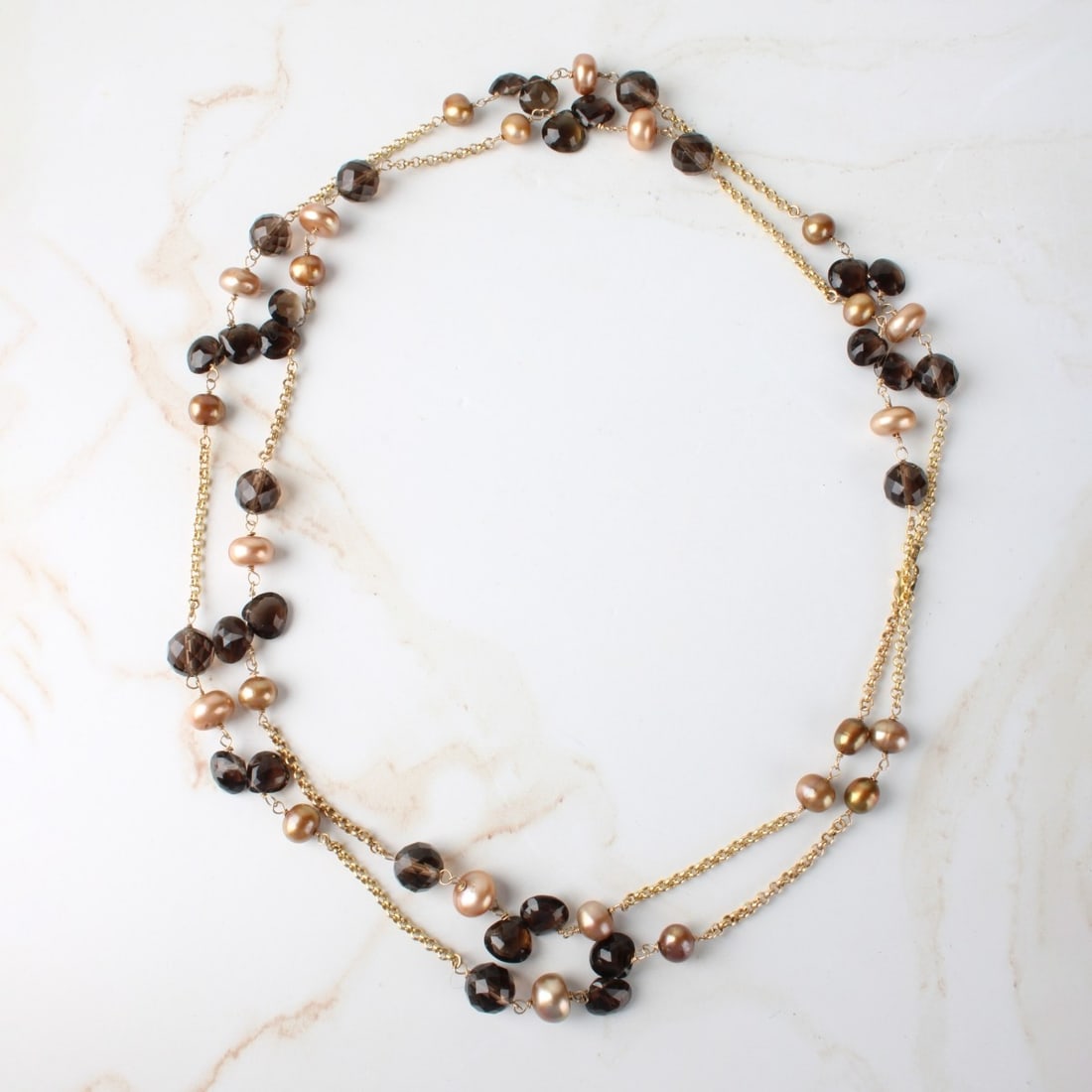 Quartz, Pearl and 14K Necklace: Vintage Italian Single Strand Faceted Smokey Quartz, Golden Pearl and 14 Karat Yellow Gold Necklace. Clasp stamped Italy 14K. Measures 43" L. Approx. weight: 49.97 grams. Kodner Galleries offers