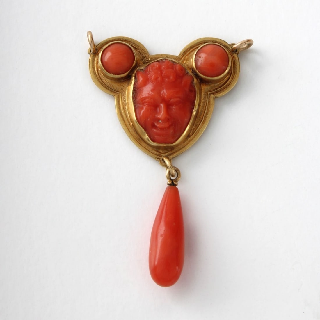 Antique Red Coral and 18K Pendant: Antique 19th Century Carved Red Coral and 18 Karat Yellow Gold Pendant. Center coral with image od Bacchus. Measures 1-1/2" L, 7/8" W. Approx. weight: 4.62 grams. Kodner Galleries offers phone and