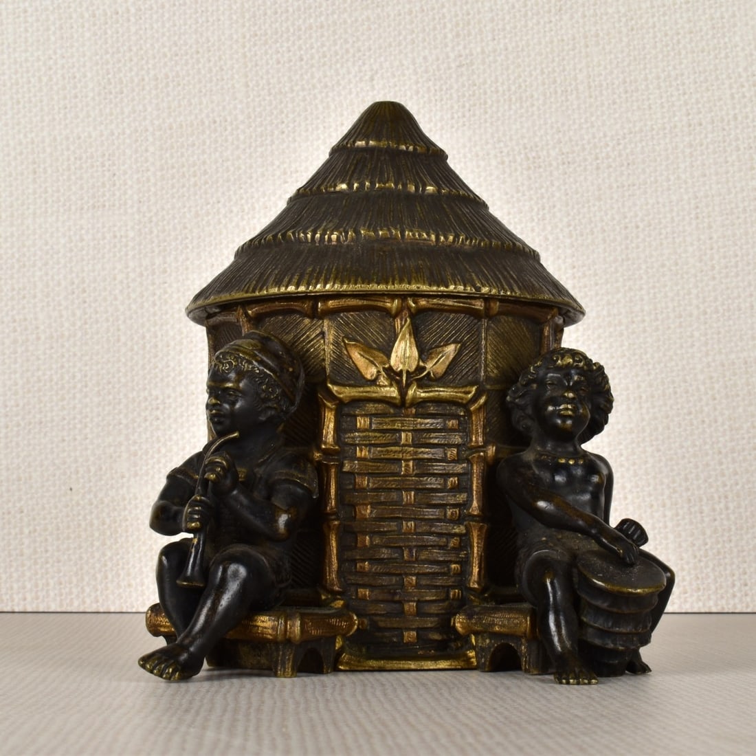 Vienna Bronze Round Desk Box: Vienna Bronze Round Desk Box. Modeled as a round thatched roof hut with a hinged lid with two young children to the sides of the door, one figure is playing a drum while the other appears ready to pla