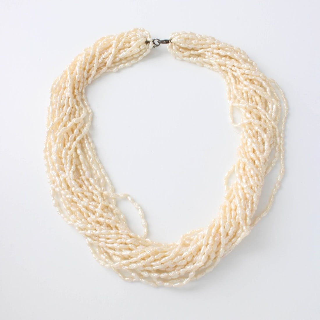 Pearl Necklace: Vintage Twenty-two Strand Small Baroque Pearl Necklace with Silver Clasp. Pearl sizes vary. Necklace measures 17-1/2" L. Approx. weight: 85.49 grams. Kodner Galleries offers phone and absentee