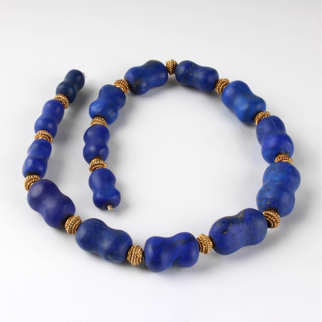 Lapis Lazuli Bead Necklace: Vintage Strand of Graduated Tumbled Lapis Lazuli Beads with Gilt Metal Spacers, No Clasp. Beads measure 17-24mm long. Approx. total weight: 86.55 grams. Kodner Galleries offers phone and absentee