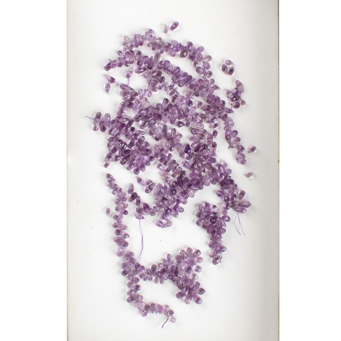 Briolette Cut Amethysts: Bag Lot of Briolette Cut Amethysts. Sizes vary. Kodner Galleries offers phone and absentee bidding at a low, flat 21% buyer’s premium without surcharge or hidden fees. For information, please