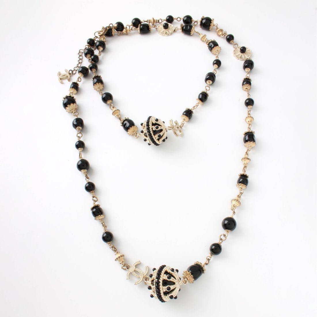 Chanel Necklace: Vintage Chanel Black Onyx and Gold Tone Metal Fashion Necklace. Signed. Measures 48" L. Kodner Galleries offers phone and absentee bidding at a low, flat 21% buyer’s premium without surcharge or