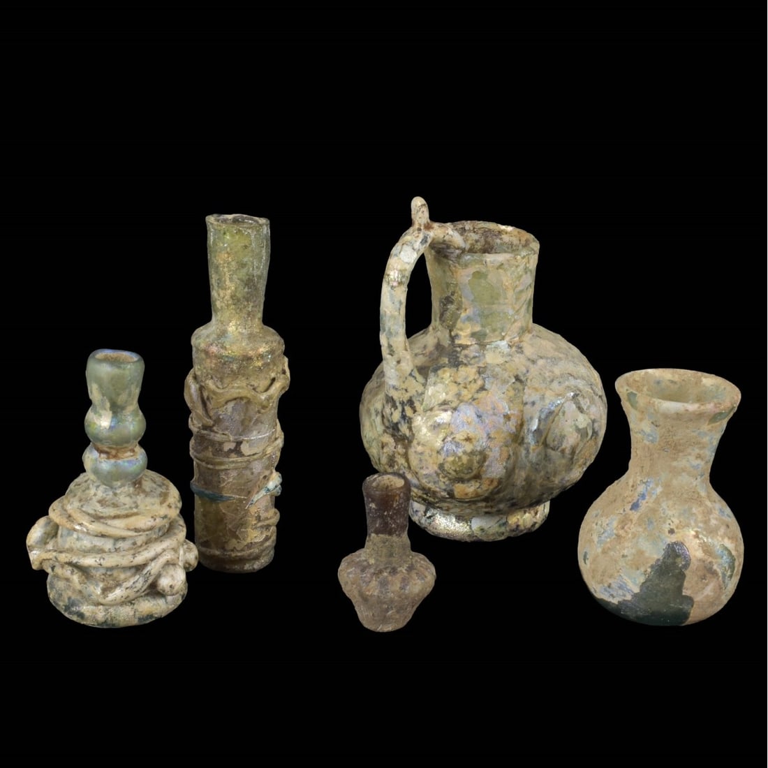 Roman Glass Artifacts: Five Piece Collection of Roman Glass Artifacts. To include beakers and vessels. Largest measures 3-1/2" H, 2-1/2" W; smallest measures 1-1/2" H, 7/8" W. Kodner Galleries offers phone and absentee bidd