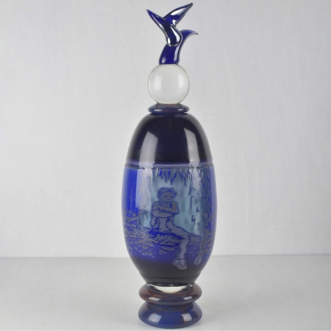 Large Art Glass Bottle: Large Art Glass Bottle with Sculptural Stopper. Artist signed and dated "97" to the lower side. Measures: 21" high, 5-1/4" diameter. A portion of the proceeds will be used to further Arts and