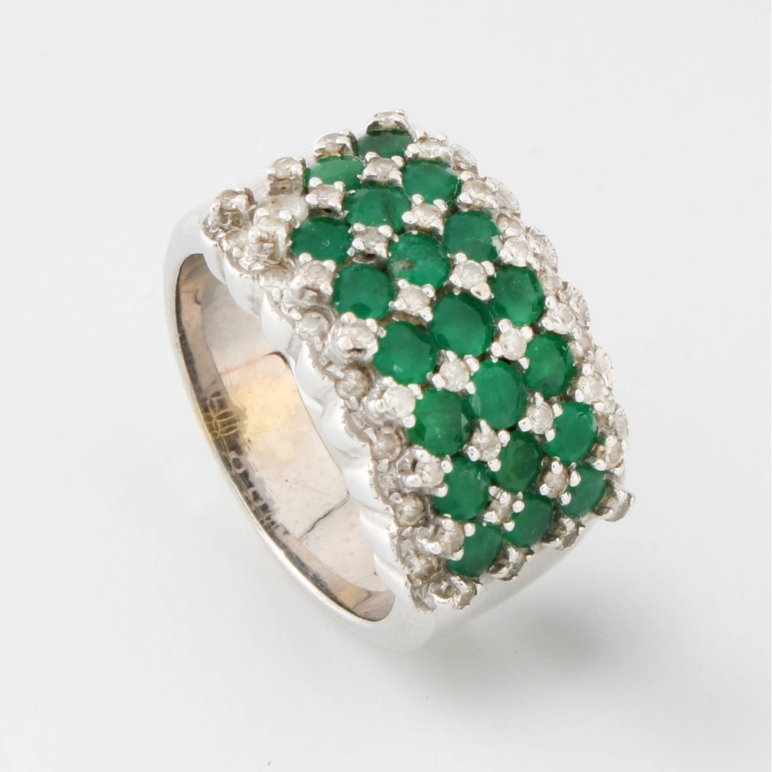 Emerald, Diamond and 18K Ring: Vintage Round Cut Emeralds and Diamonds and 18 Karat White Gold Wide Band. Diamonds G-H color, VS-SI clarity. Stamped 18K. Ring size 7-1/2. Approx. weight: 12.38 grams. Kodner Galleries offers phone a