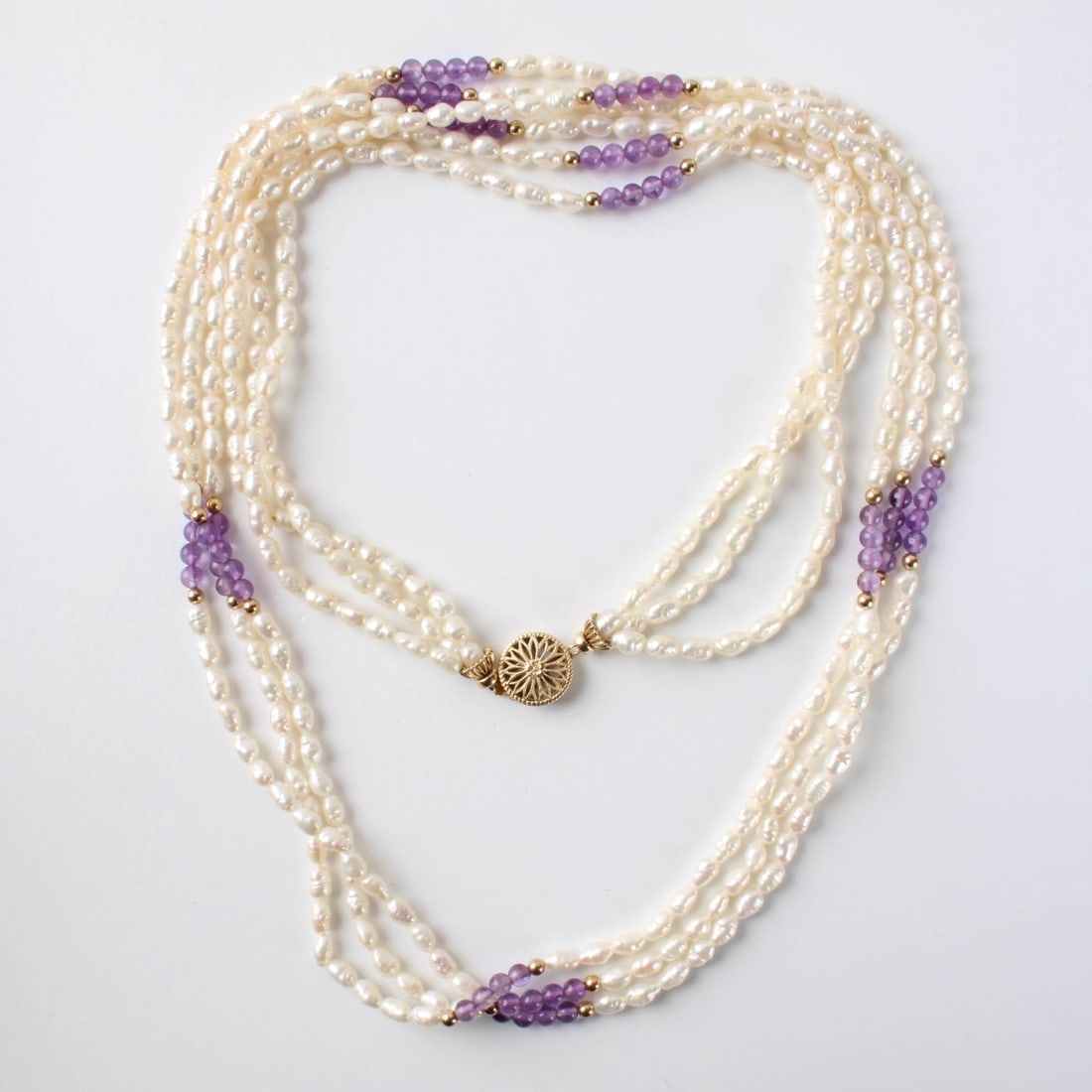 Pearl and Amethyst Necklace: Vintage Three Strand 4mm Baroque Pearl, Amethyst Bead and Yellow Gold Filled Necklace. Measures 31" L. Approx. weight: 51.84 grams. Condition: Good condition. Estimate: $50.00 - $150.00 In-House