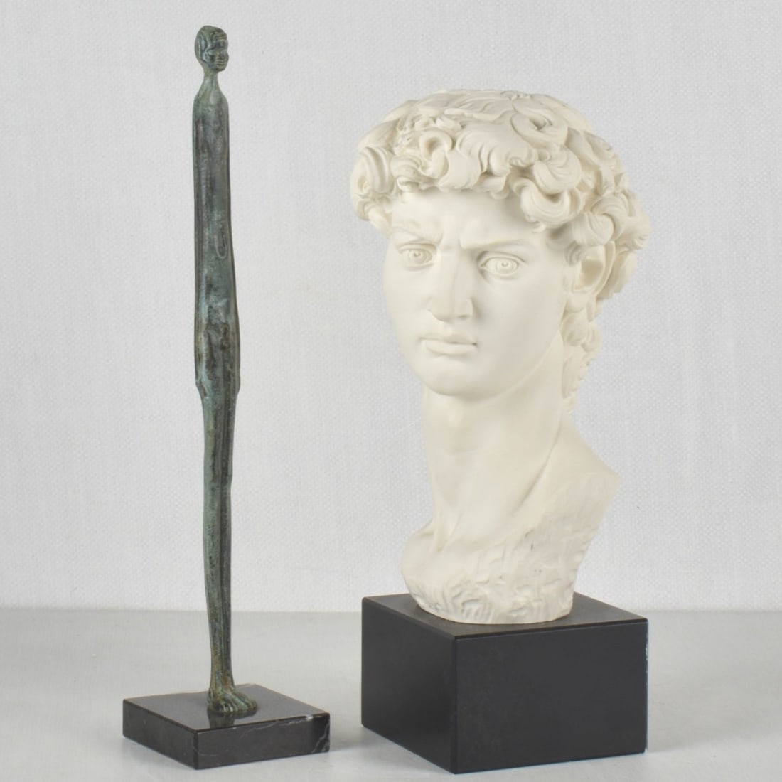 Reproduction Sculptures: Two Vintage Reproduction Sculptures. To include a reconstituted marble sculpture on stone base after Michelangelo Buonarroti, "David" and a vintage verdigris patinated metal sculpture after the