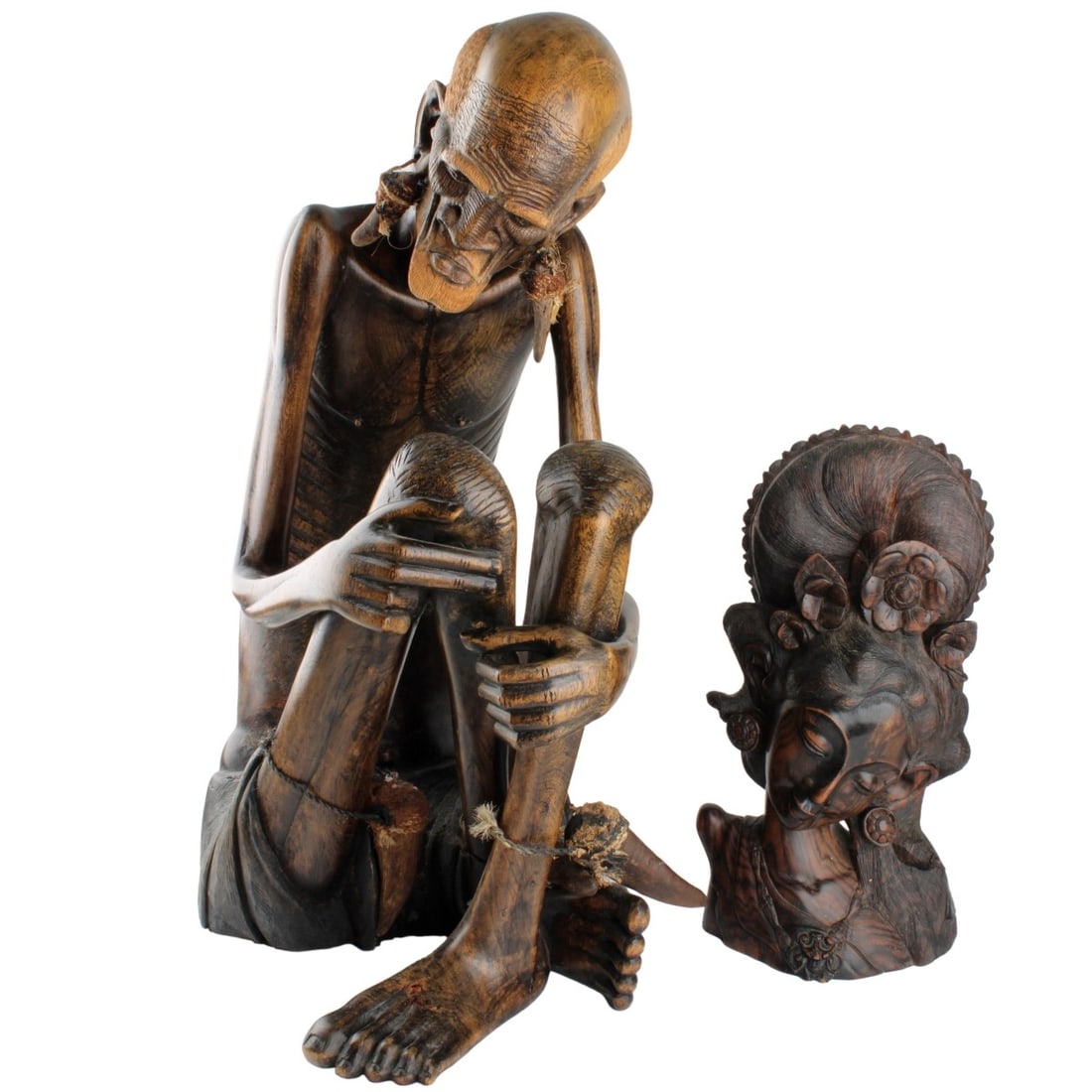 Vintage Carved Wood Figures: Two (2) Vintage Carved Figures Most Likely Ebony Wood. One (1) Tribal emancipated seated Medicine man along with a carved woman bust. Medicine man measures: 22-1/2" high, 9" wide, 14" deep, bust