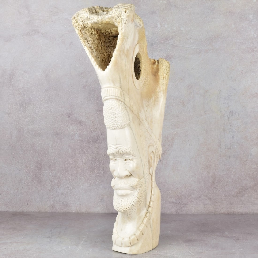Exceptionally Large Carved Bone Figure: Exceptionally Large Carved Giraffe Leg Bone Sculptural Figure of an African Man. Signed to the bottom side of the sculpture. Measures: 21-1/2" high, 5-3/4" wide, 9-1/2" deep. Kodner Galleries offers