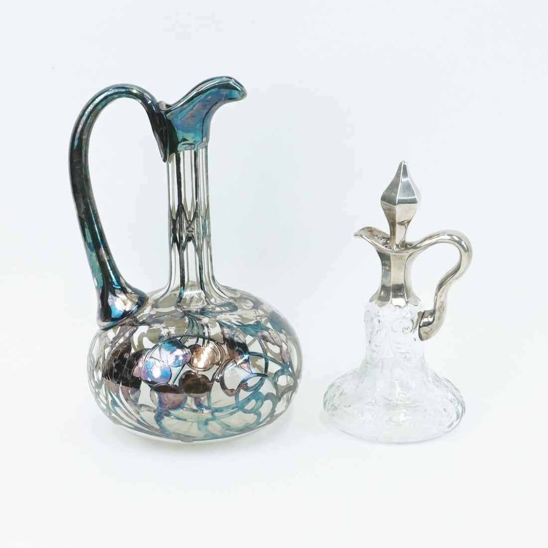 Silver Mounted Cruet and Ewer: Antique Sterling Silver Mounted Cruet and Ewer. Cruet with raised floral and scrolling design. Ewer with Art Nouveau fruit and scrolling vine design. Ewer with engraved dedication dated 1914. Ewer mea