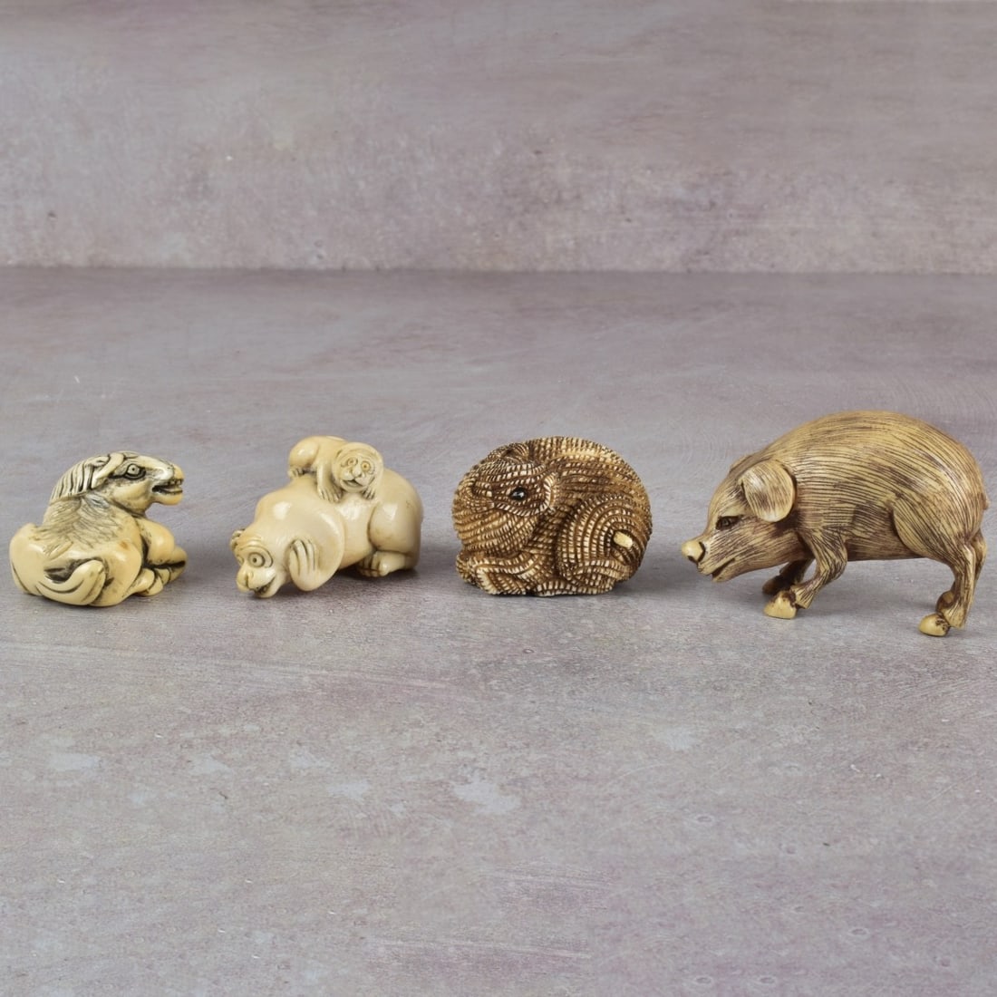 Collection of Japanese Sculptures: Collection of Four (4) Antique Japanese Carved Monochrome Figural Sculptures. Consisting of three (3) netsuke's artist signed, one (1) boar figure, boar figure measures: 1-1/2" high, 2-1/4" wide, 1" w