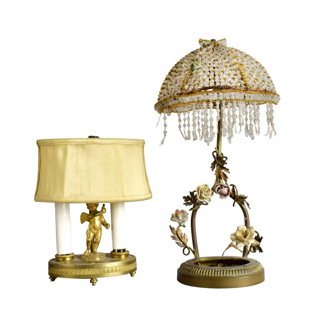 Two Bronze Vanity Lamps: Two (2) Bronze Vanity Lamps. One with two light Bronze Cherub and base. 8"H the other with beaded shade and porcelain flowers. 13" H. Kodner Galleries offers phone and absentee bidding at a low, flat