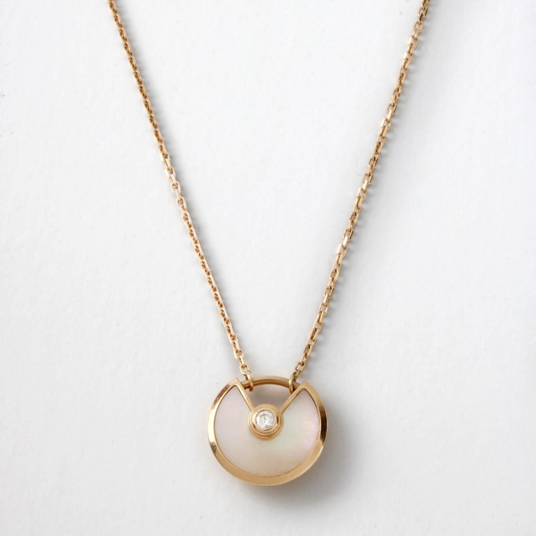 Cartier Amulet Necklace: Cartier Diamond, Mother of Pearl and 18 Karat Yellow Gold Amulet Necklace with Cartier Box. Signed, stamped 750 to clasp. Pendant measures 7/8" diam; chain measures 16" L. Approx. weight: 2.89 grams. 