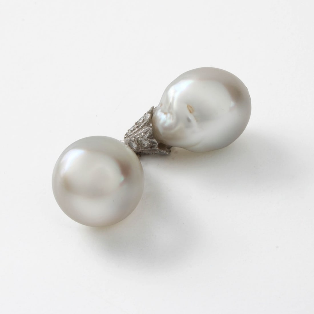 Pearl Ear Stud Enhancers: Vintage South Sea Baroque 13mm Pearl, Round Brilliant Cut Diamond and 14 Karat White Gold Ear Stud Enhancers. Pearls with good luster and polish. Overall measure 7/8" L. Approx. total weight: 8.50 gra