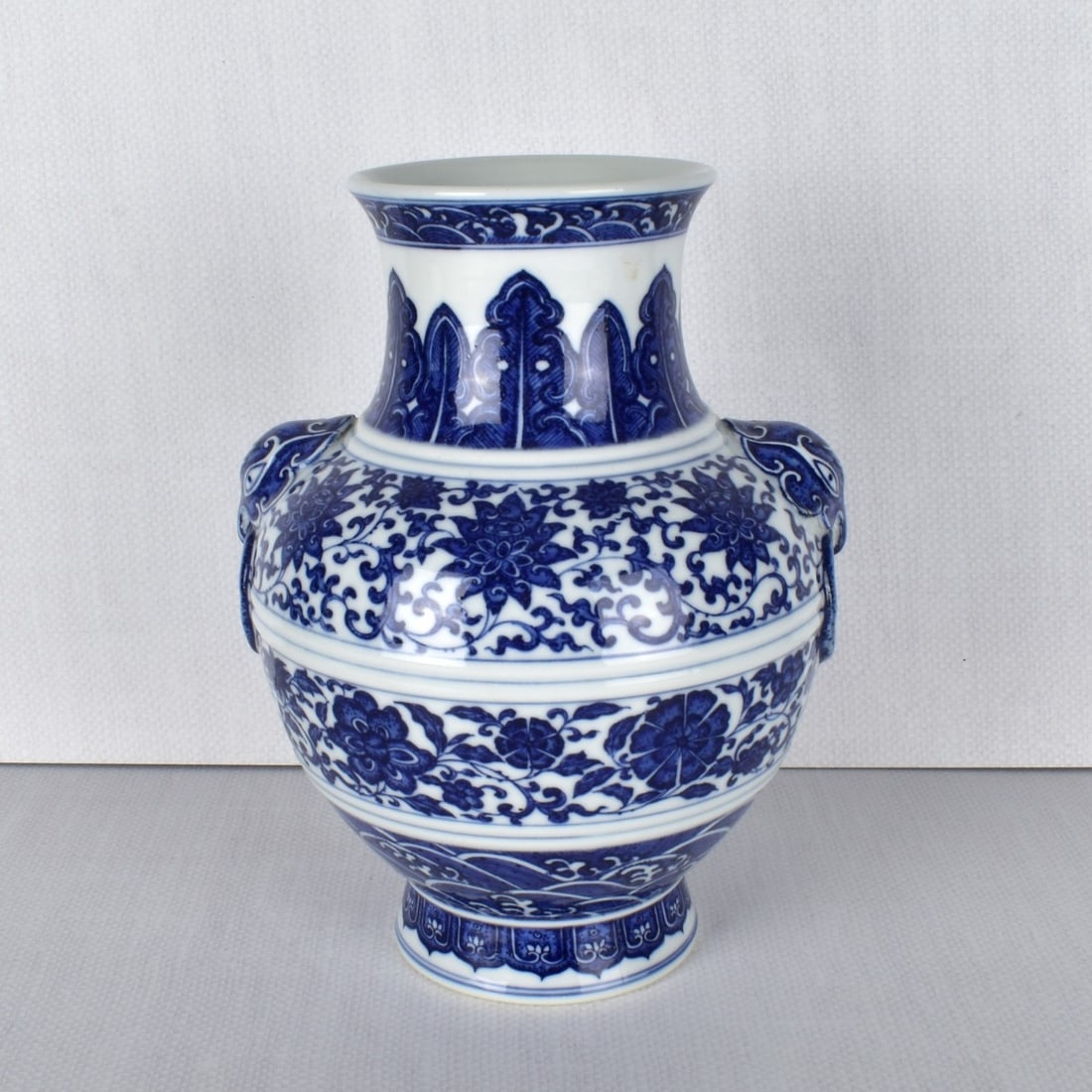 Chinese Blue and White Porcelain Vase: Chinese Blue and White Porcelain Flower Scroll Vase. Bears the Quinlong seal under glaze. Measures: 9-1/4" H, 7-1/2" Dia. Kodner Galleries offers phone and absentee bidding at a low, flat 21% buyer?s 