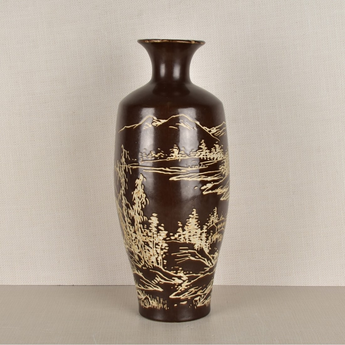 Japanese Incised Pottery Vase: Japanese Okinawa Region Kiln Carved Incised Pottery Vase with a Landscape Motif on a Dark Chocolate Ground. Artist signed to the side. 20th century. Measures: 15-1/2" H, 6" Dia.Kodner Galleries offers