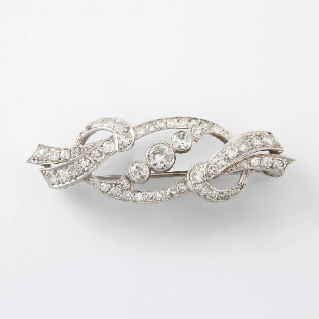 Diamond and Platinum Brooch: Antique Approx. 2.0 Carat Round Cut Diamond and Platinum Brooch. Diamonds F-G color, VS-SI clarity. Measures 5/8" H, 1-3/4" W. Approx. weight: 6.88 grams. Kodner Galleries offers phone and absentee bi