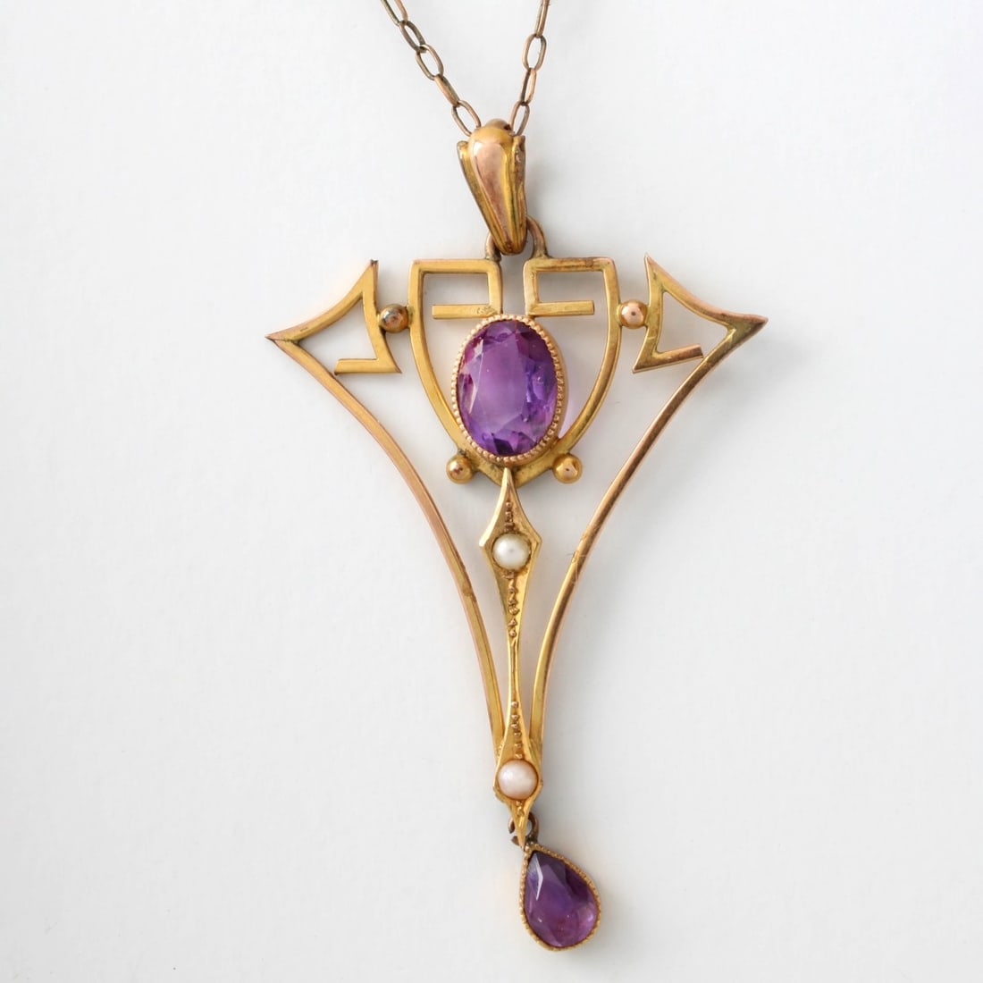 Art Nouveau Amethyst, Pearl and 9K Necklace: Antique Circa 1900 Art Nouveau Amethyst, Natural Pearl and 9 Karat Yellow Gold Pendant Necklace. Pendant measures 2" L, 1-1/4" W; chain measures 17" L. Approx. weight: 4.05 grams. Kodner Galleries off