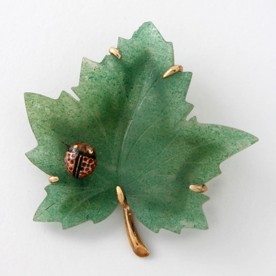 Jade and 14K Leaf Pin: Vintage Green Jade and 14 Karat Yellow Gold Leaf Pin with Lady Bug. Stamped 14K. Measures 1-5/*" H, 1-5/8" W. Approx. weight: 9.32 grams. Kodner Galleries offers phone and absentee bidding at a low, f