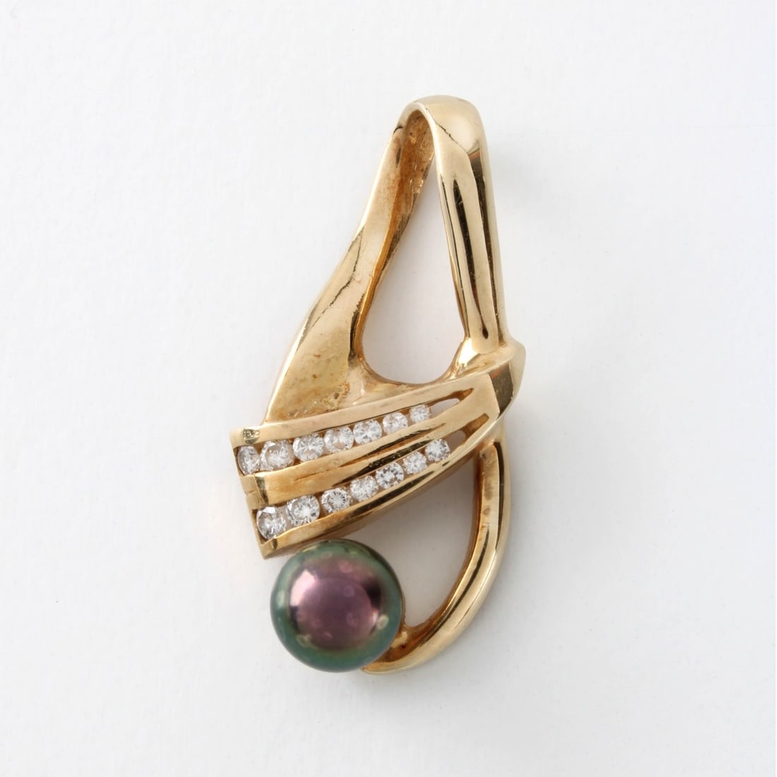 Pearl, Diamond and 14K Pendant: Vintage 7mm South Sea Black Pearl, Channel Set Small Round Brilliant Cut Diamond and 14 Karat Yellow Gold Pendant. Pearl with good luster and polish. Measures 1-1/4" L, 5/8" W. Approx. weight: 5.55 gr
