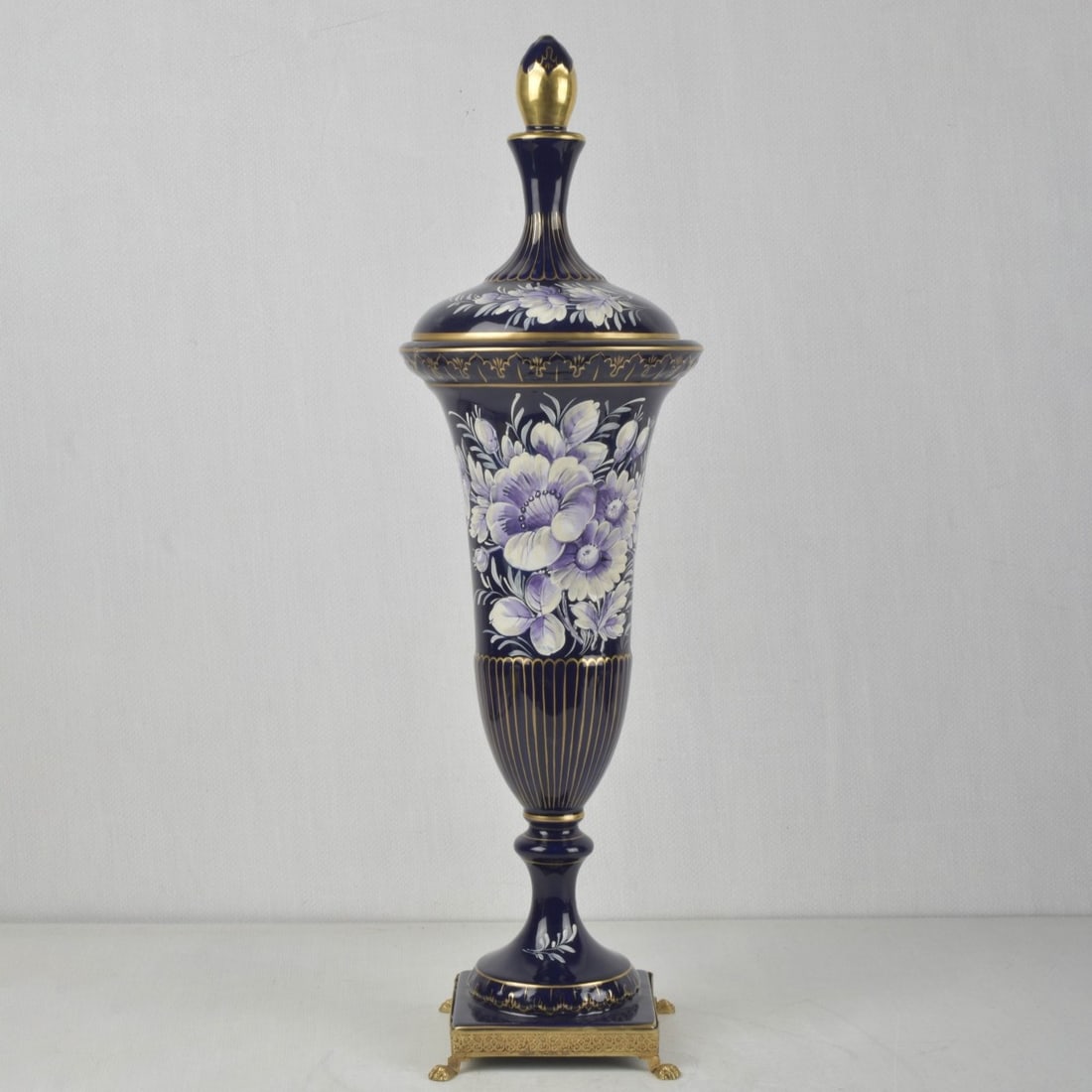 Vintage Keramos Italian Capodimonte Vase: Vintage Keramos Italian Capodimonte Cobalt Blue Porcelain Vase with Cover on a Gold Tone Paw Foot Base. Enameled Flowers and a gold enameled top. Artist signed to the side. Measures: 23-1/2" high, 7"