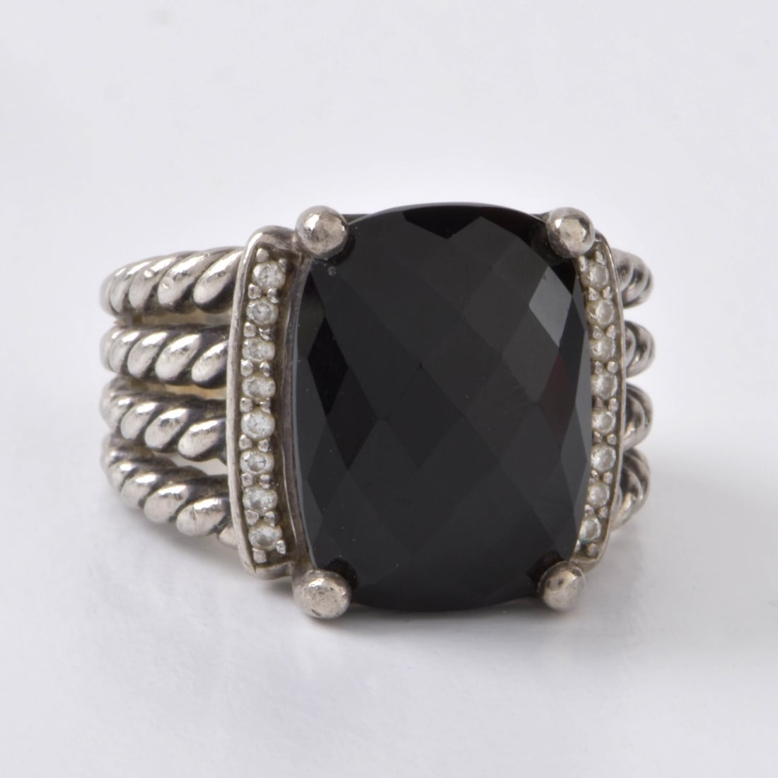 David Yurman Onyx and Sterling Ring: Vintage David Yurman Oval Faceted Black Onyx and Sterling Silver Ring. Signed, stamped 925. Ring size 5-1/2. Approx. weight: 11.22 grams. Kodner Galleries offers phone and absentee bidding at a low, f