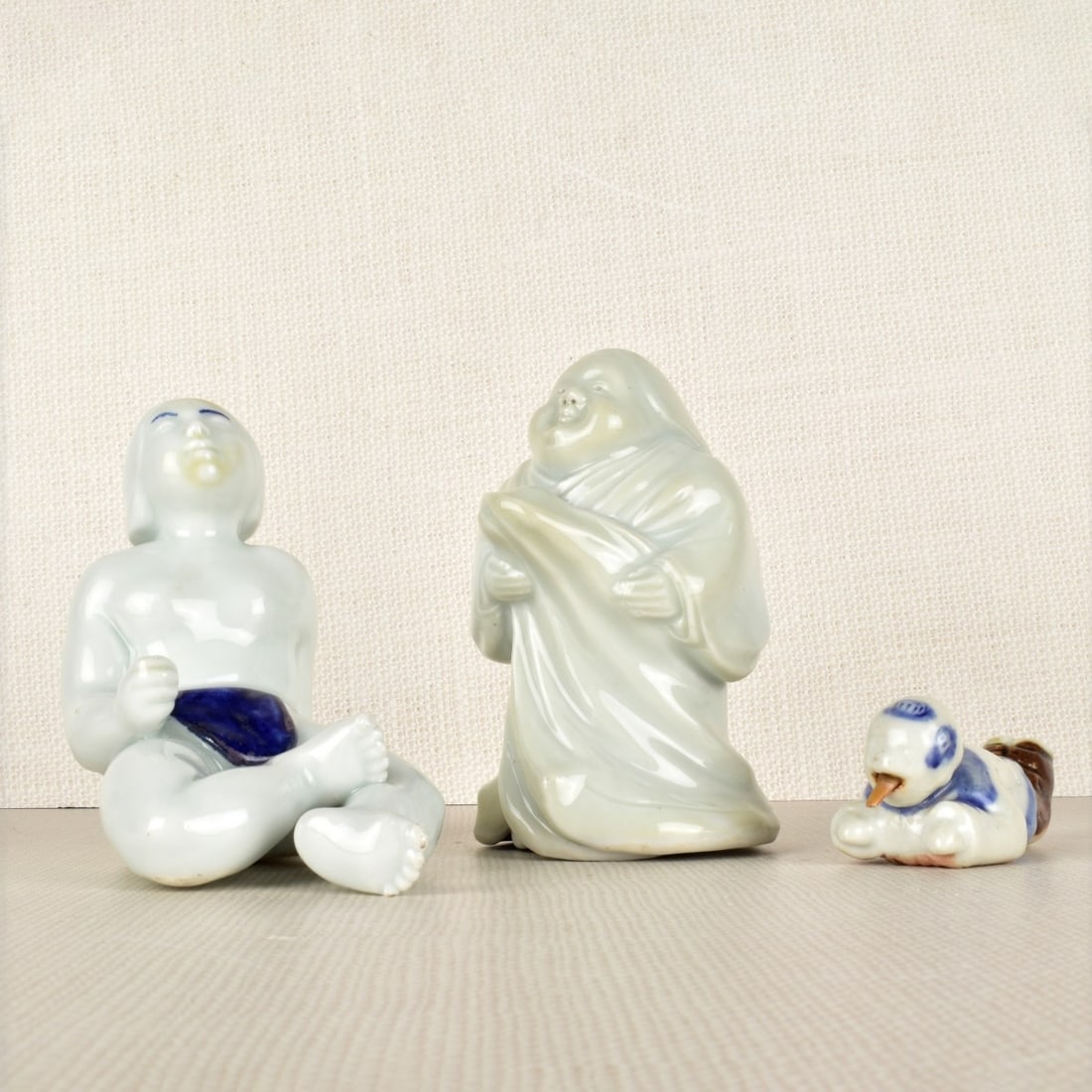 Chinese Porcelain Figures: Three (3) Chinese Porcelain Figures, One (1) A Small Water Dropper, Unsigned, One (1) Seated Woman, Unsigned and One (1) Standing Man, Artist Signed. Late 20th century. Standing man measures: 5" H, 3"