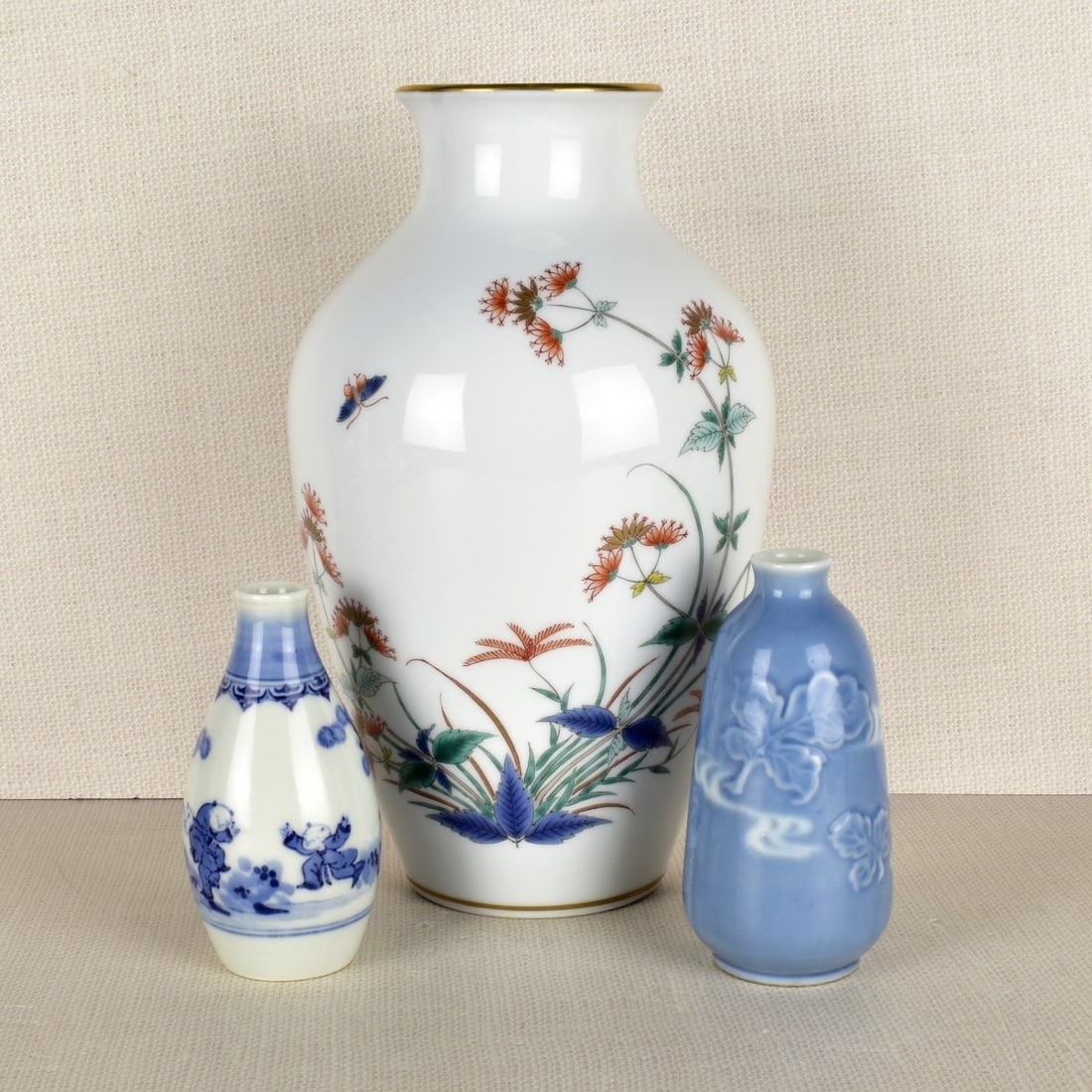 Japanese Porcelain Vases: Three (3) Japanese Porcelain Vases. One (1) Japanese "Ashibi" bottle pot shaped vase with painted pastel colored flowers, signed on the bottom, measures: 10-1/2" H, 6-1/2 dia., One (1) Japanese blue a