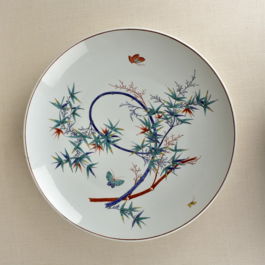 Japanese Porcelain Platter: Japanese Studio Porcelain Large Serving Platter Decorated with Painted Butterflies and Bamboo. Late 20th century. Unsigned. Measures: 2-5/8" H, 17-3/4" D. Kodner Galleries offers phone and absentee bi